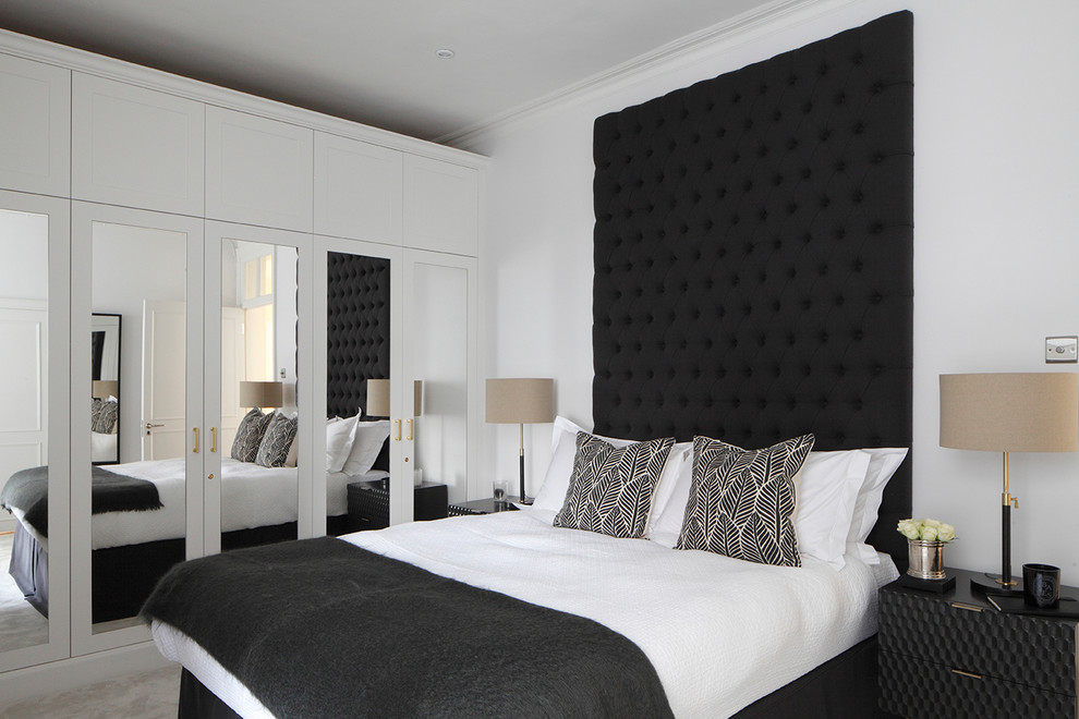 Modelo de dormitorio actual de tamaño medio con paredes blancas, moqueta y suelo gris