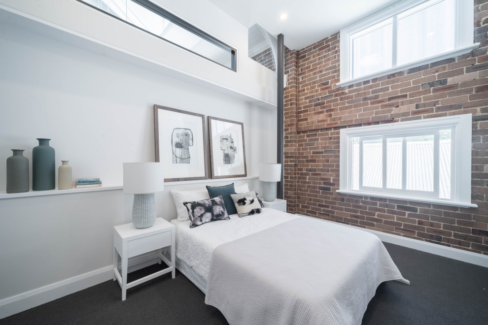 This is an example of an industrial bedroom in Sydney with brick walls.