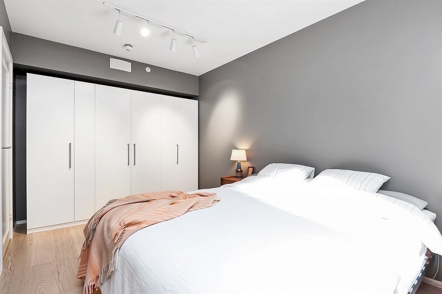 Example of a mid-sized minimalist master light wood floor bedroom design in Other with gray walls