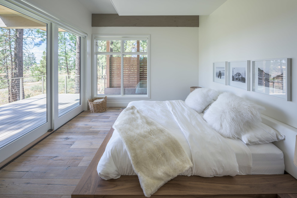 Idee per una camera da letto minimalista con pareti bianche, pavimento in legno massello medio e nessun camino