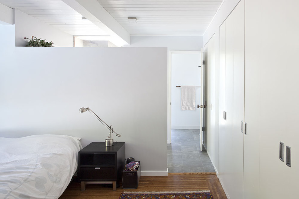 Cette photo montre une chambre rétro avec un mur gris et un sol en bois brun.