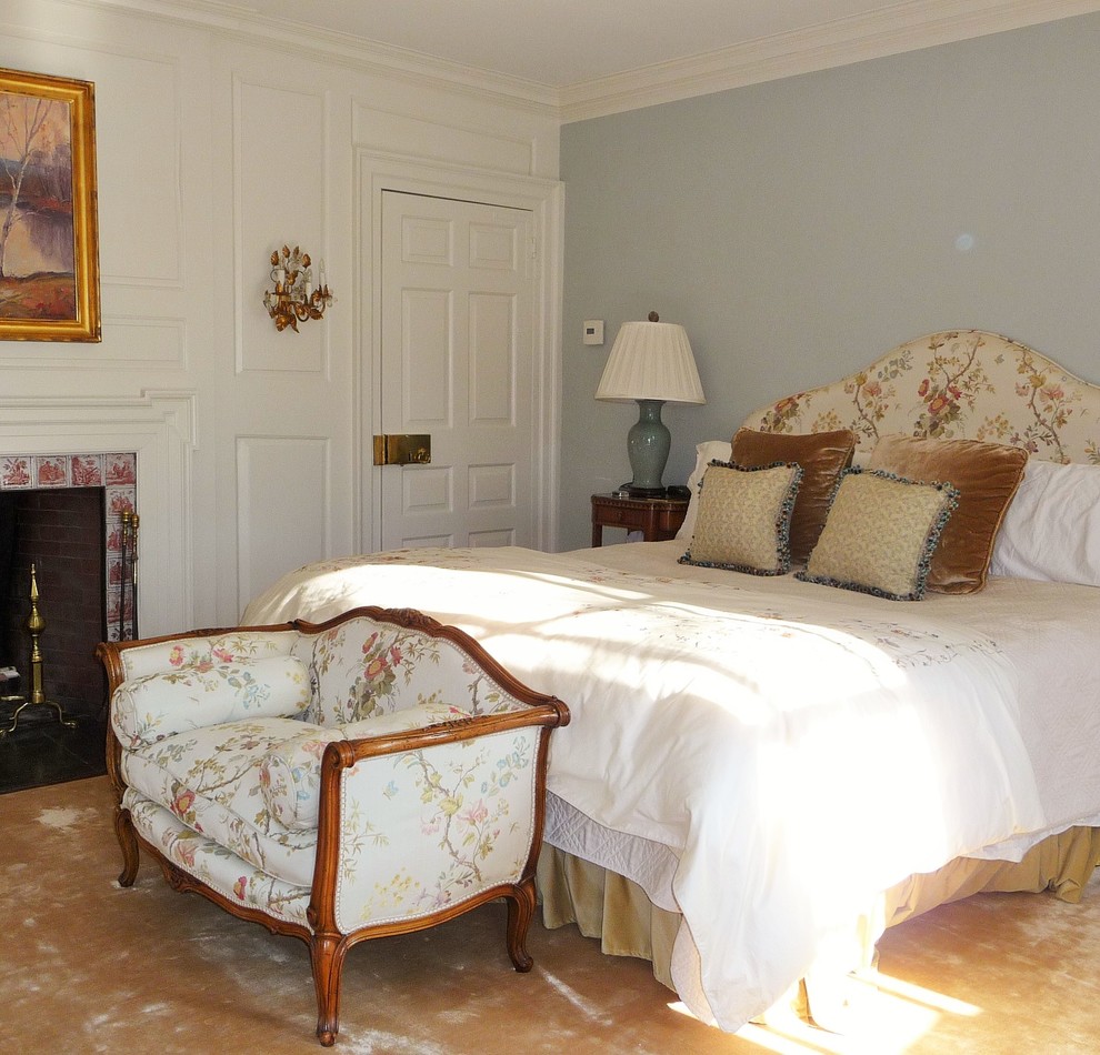 Immagine di una camera matrimoniale chic di medie dimensioni con pareti blu, moquette, camino classico, cornice del camino piastrellata e pavimento beige