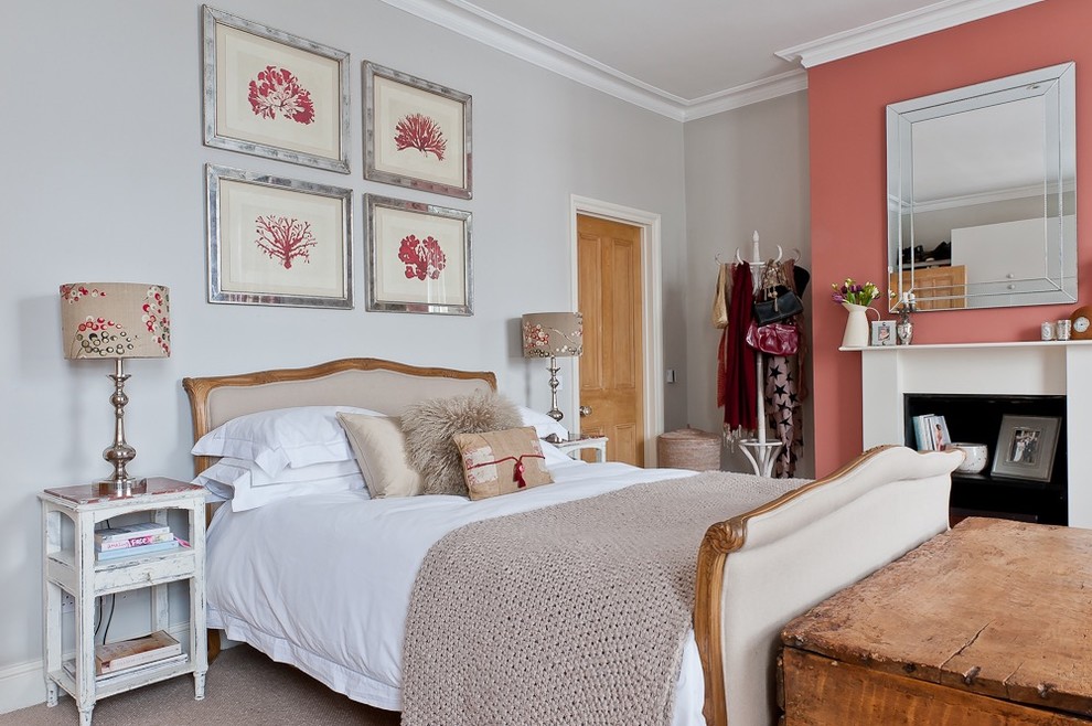 На фото: хозяйская спальня среднего размера в стиле шебби-шик с розовыми стенами, ковровым покрытием, стандартным камином, фасадом камина из дерева и бежевым полом с