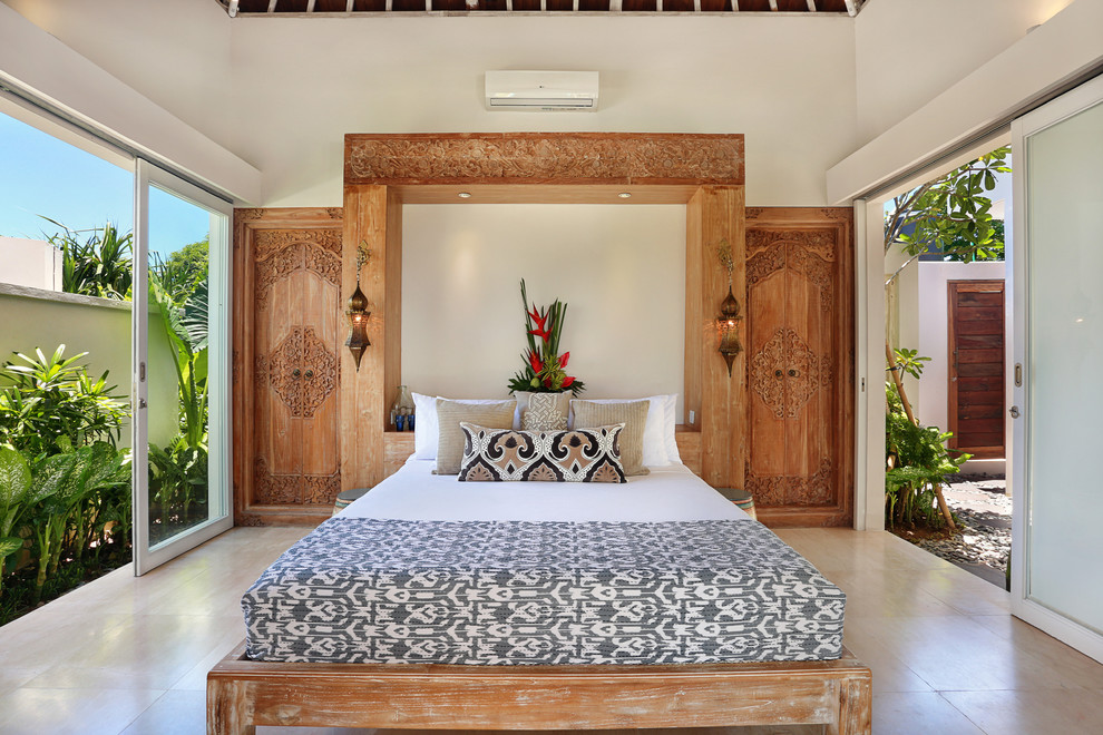 Ispirazione per una camera matrimoniale tropicale con pavimento in legno massello medio