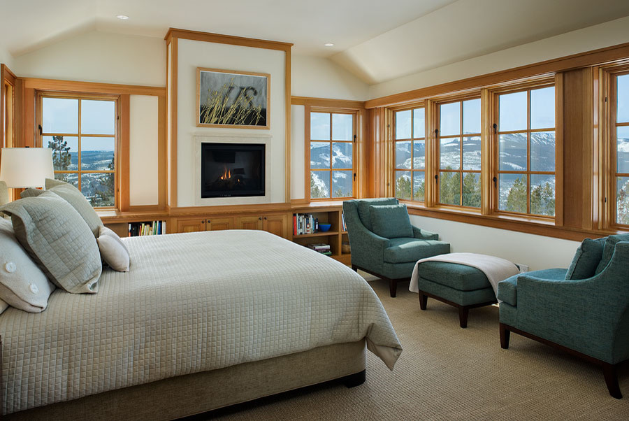 Example of a large mountain style master carpeted and beige floor bedroom design in Other with a standard fireplace, white walls and a wood fireplace surround