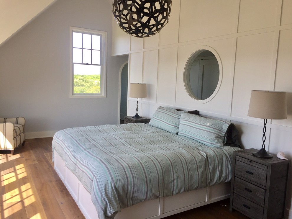 Ejemplo de dormitorio principal campestre de tamaño medio sin chimenea con paredes blancas, suelo de madera en tonos medios y suelo marrón
