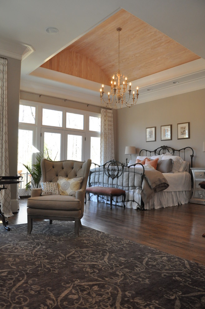 Inspiration pour une très grande chambre parentale traditionnelle avec un mur beige et un sol en bois brun.
