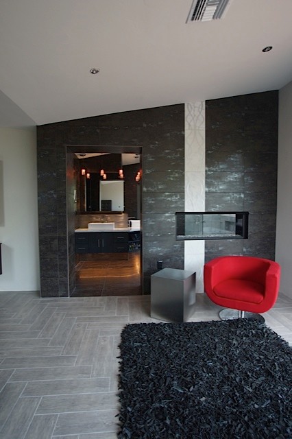 Пример оригинального дизайна: хозяйская спальня среднего размера в современном стиле с серыми стенами, полом из керамической плитки, горизонтальным камином и фасадом камина из плитки