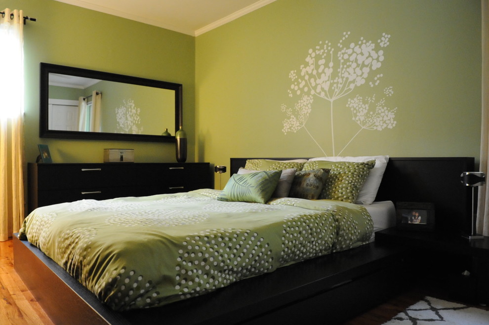 Imagen de dormitorio principal contemporáneo de tamaño medio sin chimenea con paredes verdes y suelo de madera clara