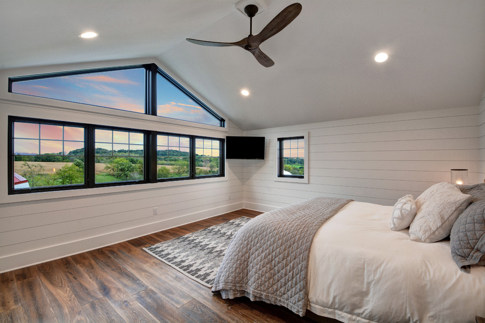 На фото: хозяйская спальня в стиле кантри с белыми стенами, темным паркетным полом и коричневым полом