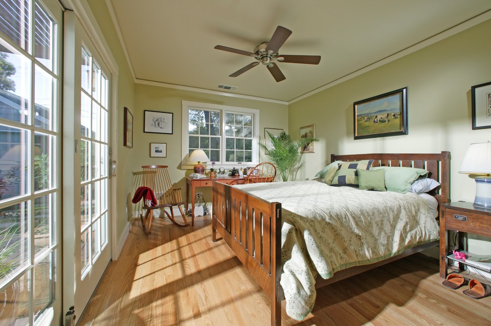 Ejemplo de dormitorio principal clásico de tamaño medio sin chimenea con paredes verdes y suelo de madera clara