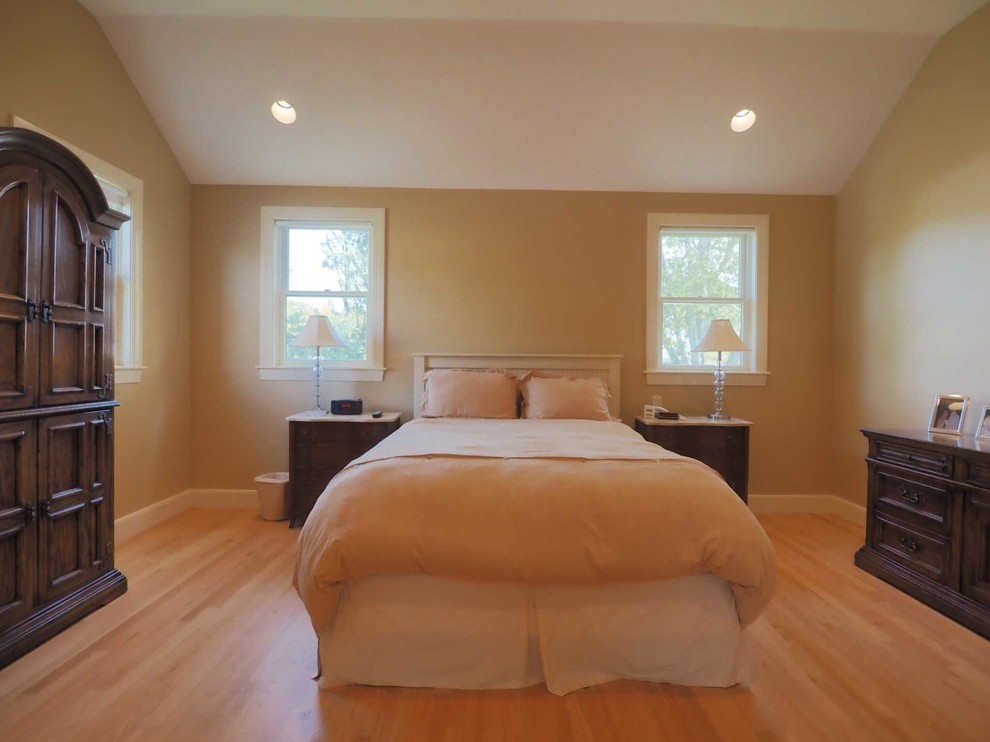 Imagen de dormitorio principal clásico renovado de tamaño medio con paredes beige y suelo de madera clara