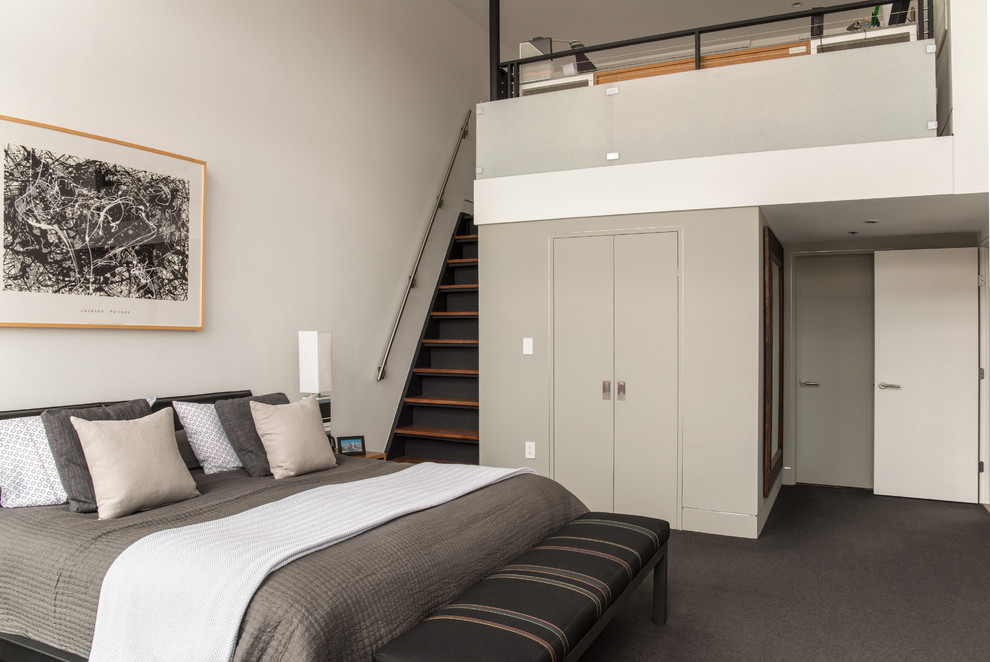Foto de dormitorio tipo loft moderno con paredes grises y moqueta