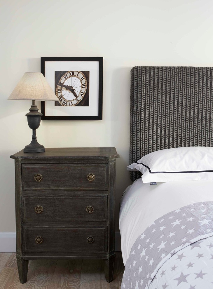 Inspiration for an urban bedroom in Oxfordshire with beige walls and medium hardwood flooring.