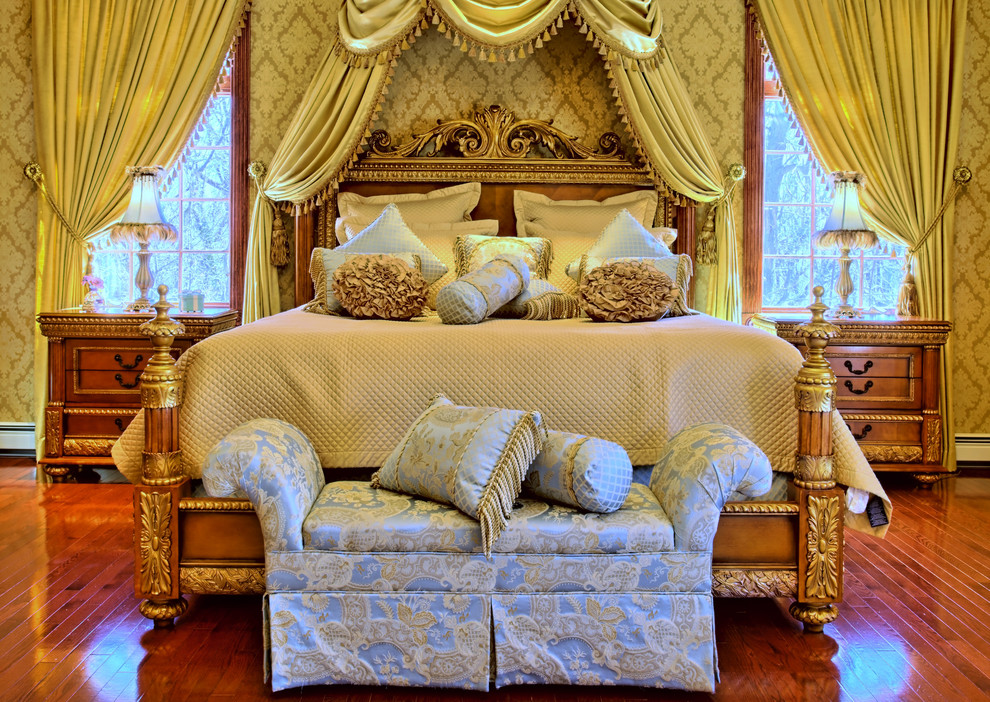 Стильный дизайн: огромная хозяйская спальня в классическом стиле с желтыми стенами, темным паркетным полом и фасадом камина из камня - последний тренд