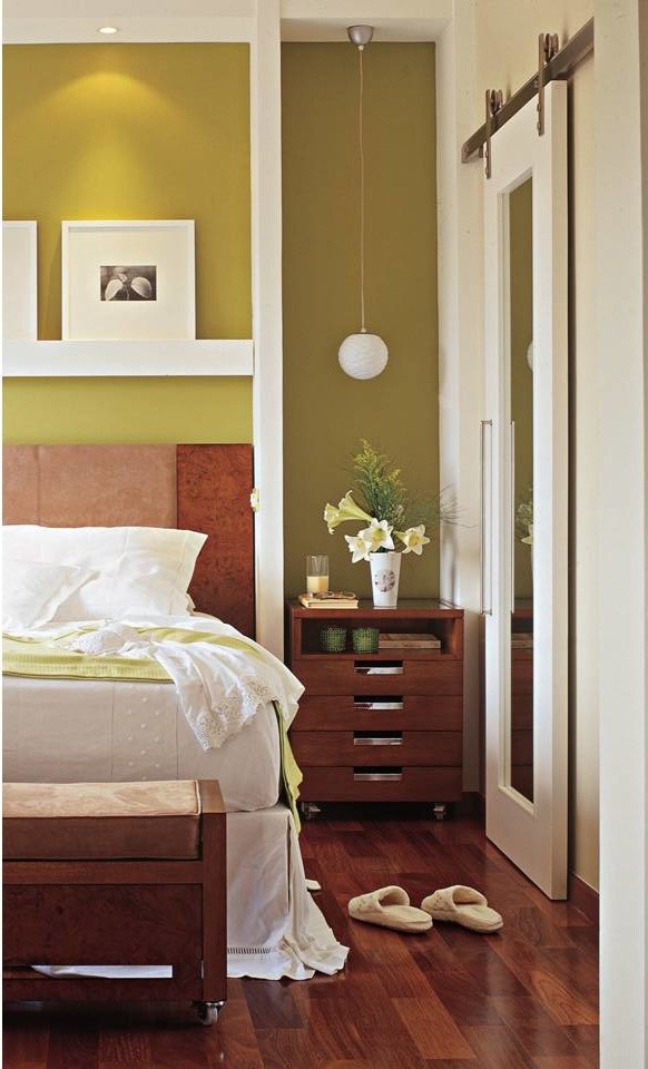 Modelo de dormitorio principal contemporáneo de tamaño medio con paredes verdes y suelo de madera en tonos medios
