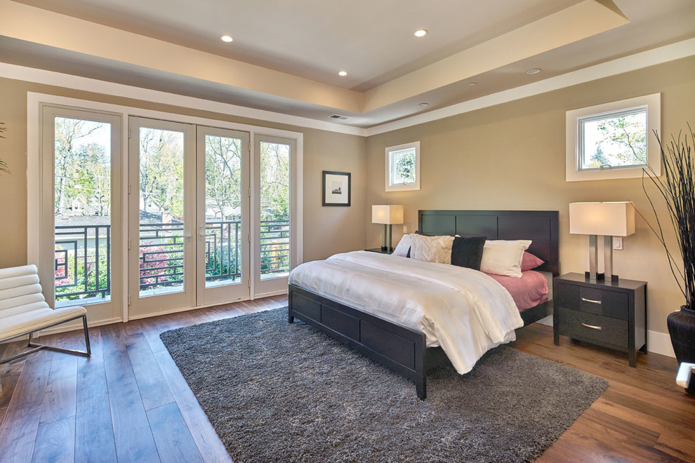 This is an example of a large contemporary master bedroom in San Francisco with beige walls, dark hardwood flooring and no fireplace.