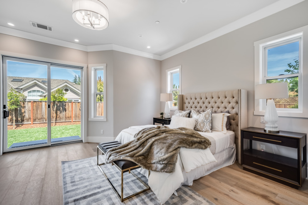 This is an example of a large rural master bedroom in San Francisco with grey walls, light hardwood flooring, no fireplace and grey floors.