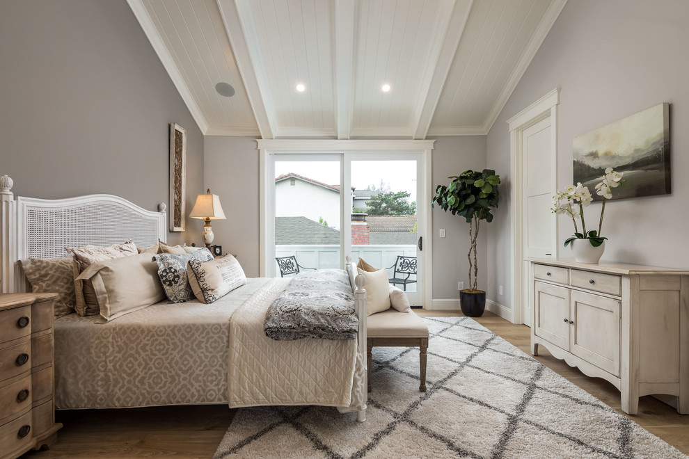 This is an example of a medium sized farmhouse master and grey and brown bedroom in San Francisco with grey walls, light hardwood flooring and brown floors.