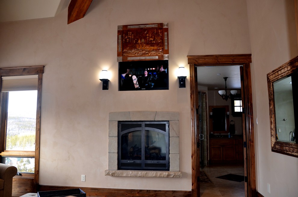Foto de dormitorio principal tradicional de tamaño medio con paredes beige, todas las chimeneas, marco de chimenea de piedra, suelo de madera oscura y suelo marrón