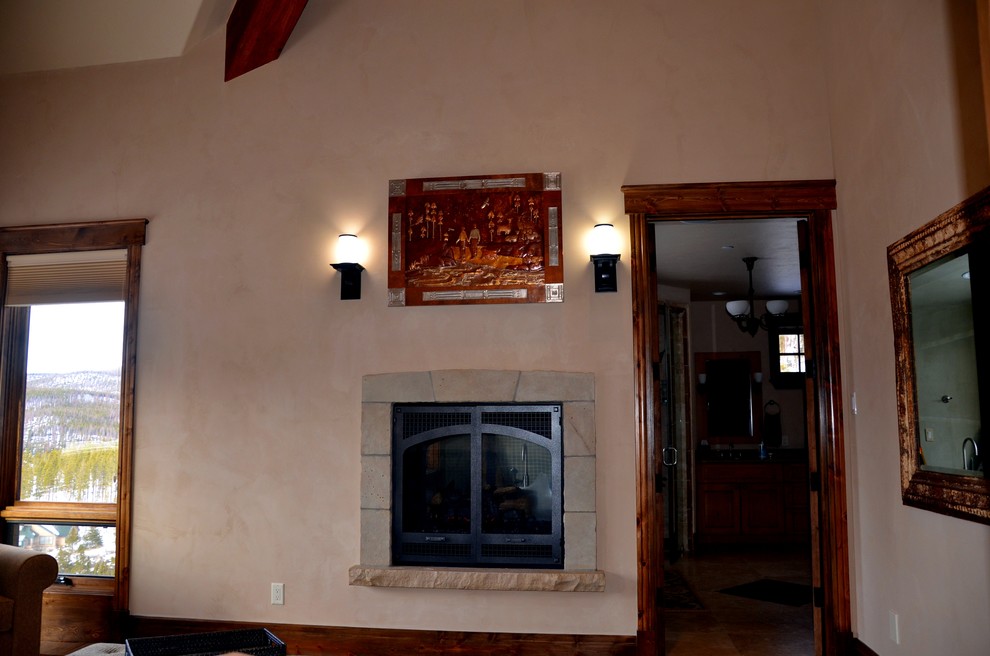 Imagen de dormitorio principal tradicional de tamaño medio con paredes beige, todas las chimeneas, marco de chimenea de piedra, suelo de madera oscura y suelo marrón
