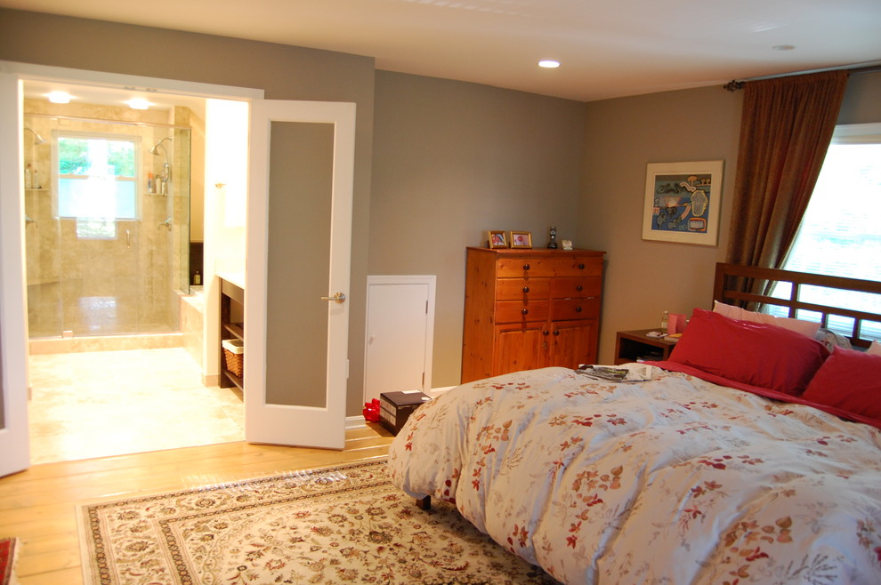 Imagen de dormitorio principal clásico de tamaño medio sin chimenea con paredes grises y suelo de madera clara