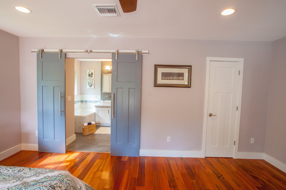 Réalisation d'une chambre parentale minimaliste de taille moyenne avec un mur gris, un sol en bois brun et un sol marron.