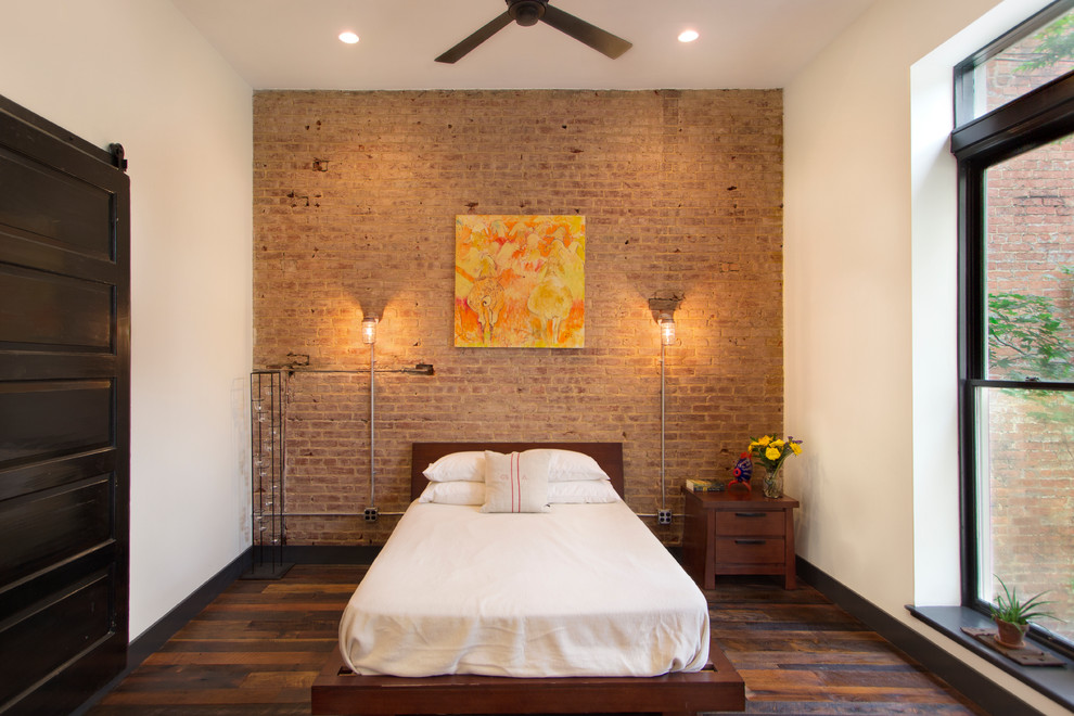 На фото: спальня в стиле лофт с белыми стенами и паркетным полом среднего тона без камина