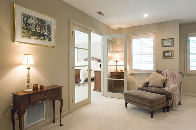 Ejemplo de dormitorio principal clásico de tamaño medio con paredes blancas, moqueta, chimenea de esquina, marco de chimenea de yeso y suelo beige