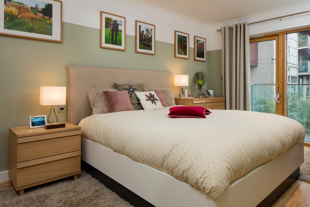 На фото: хозяйская спальня среднего размера в стиле неоклассика (современная классика) с зелеными стенами и паркетным полом среднего тона с