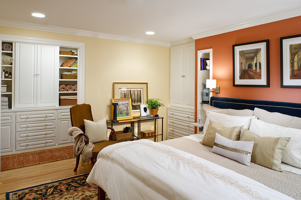 Trendy master medium tone wood floor bedroom photo in DC Metro with orange walls