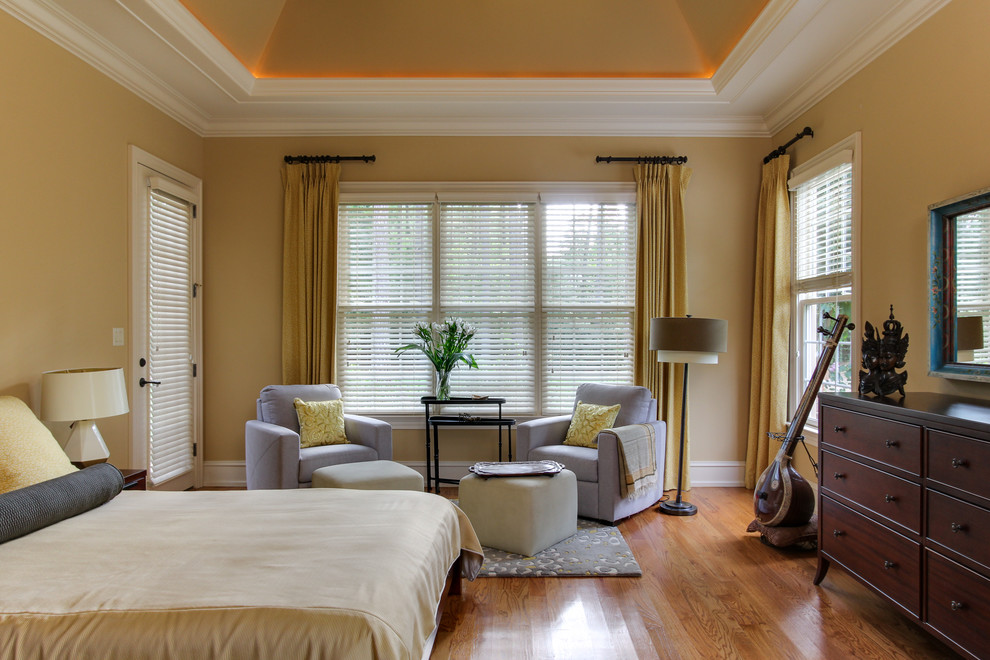 Foto de dormitorio principal clásico renovado de tamaño medio sin chimenea con paredes amarillas y suelo de madera en tonos medios