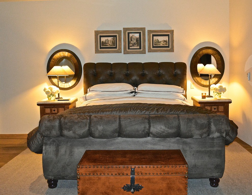 На фото: большая хозяйская спальня в средиземноморском стиле с белыми стенами и темным паркетным полом