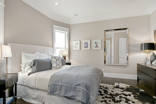 A bedroom with a white bed and a cow hide rug, creating a stylish and cozy ambiance.

