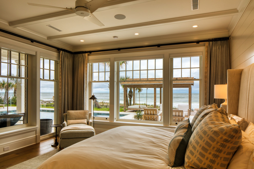 Foto di una grande camera matrimoniale costiera con pareti beige, pavimento in legno massello medio e pareti in legno