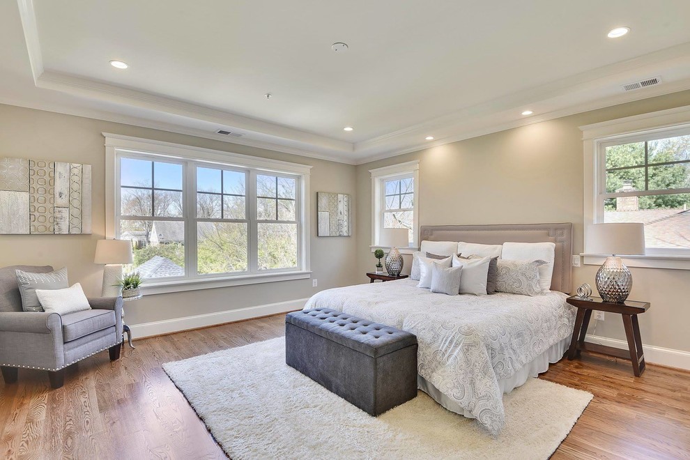 Medium sized traditional master and grey and brown bedroom in DC Metro with medium hardwood flooring, beige walls and brown floors.