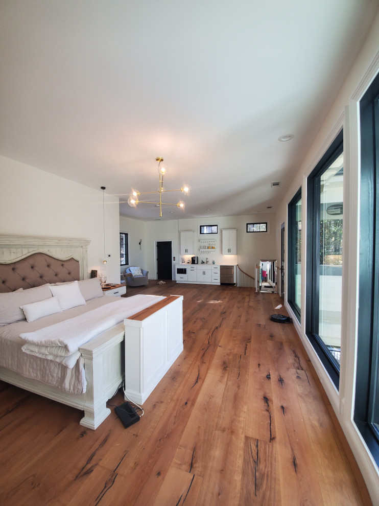Bedroom - large modern loft-style light wood floor bedroom idea in Other with beige walls