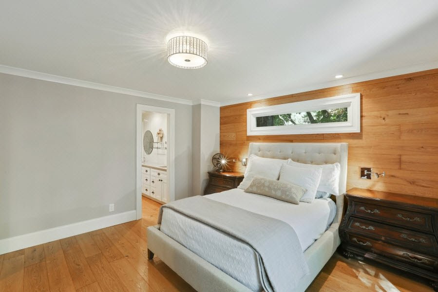 Exemple d'une chambre parentale moderne de taille moyenne avec un mur beige, parquet clair et du lambris.