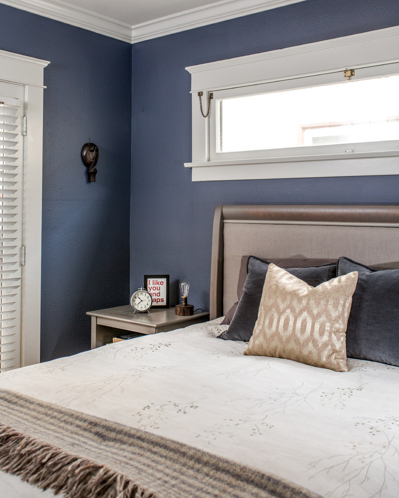 Cette image montre une chambre parentale traditionnelle de taille moyenne avec un mur bleu et un sol en bois brun.