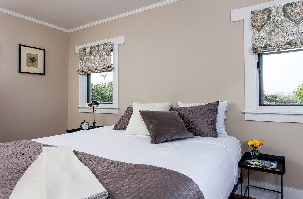 Diseño de dormitorio principal de estilo americano grande sin chimenea con paredes beige y suelo de madera en tonos medios