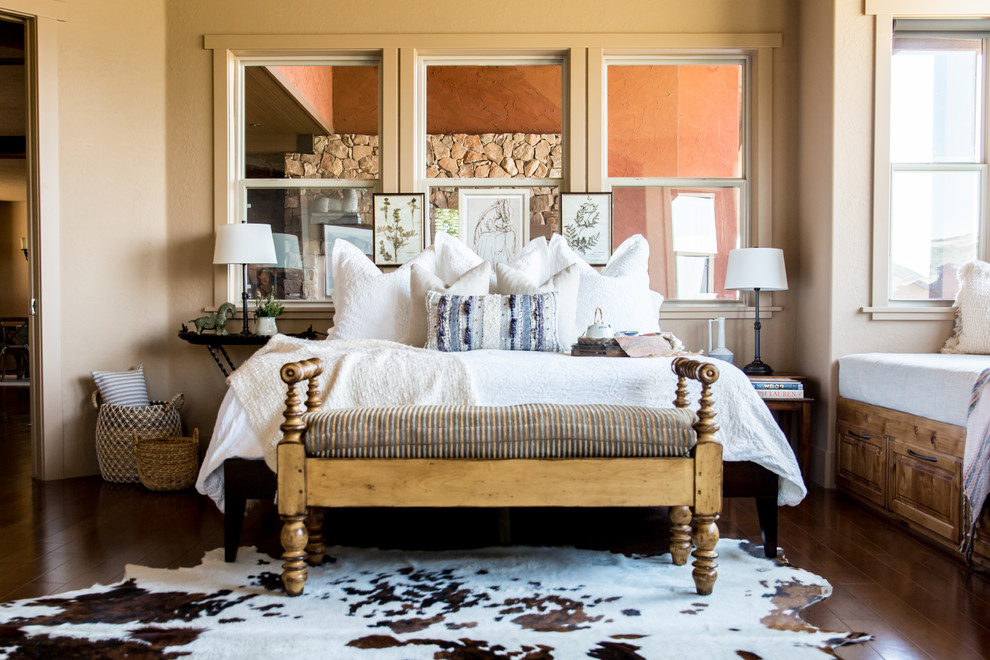 Foto di una camera da letto country con pareti beige, parquet scuro e pavimento marrone