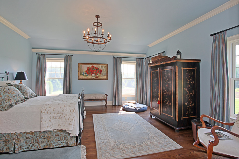 Ejemplo de dormitorio principal campestre sin chimenea con paredes azules y suelo de madera en tonos medios