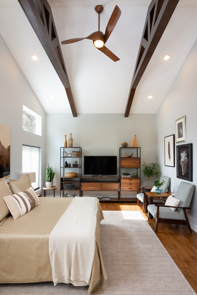 Modernes Gästezimmer mit weißer Wandfarbe, braunem Holzboden und braunem Boden in Detroit