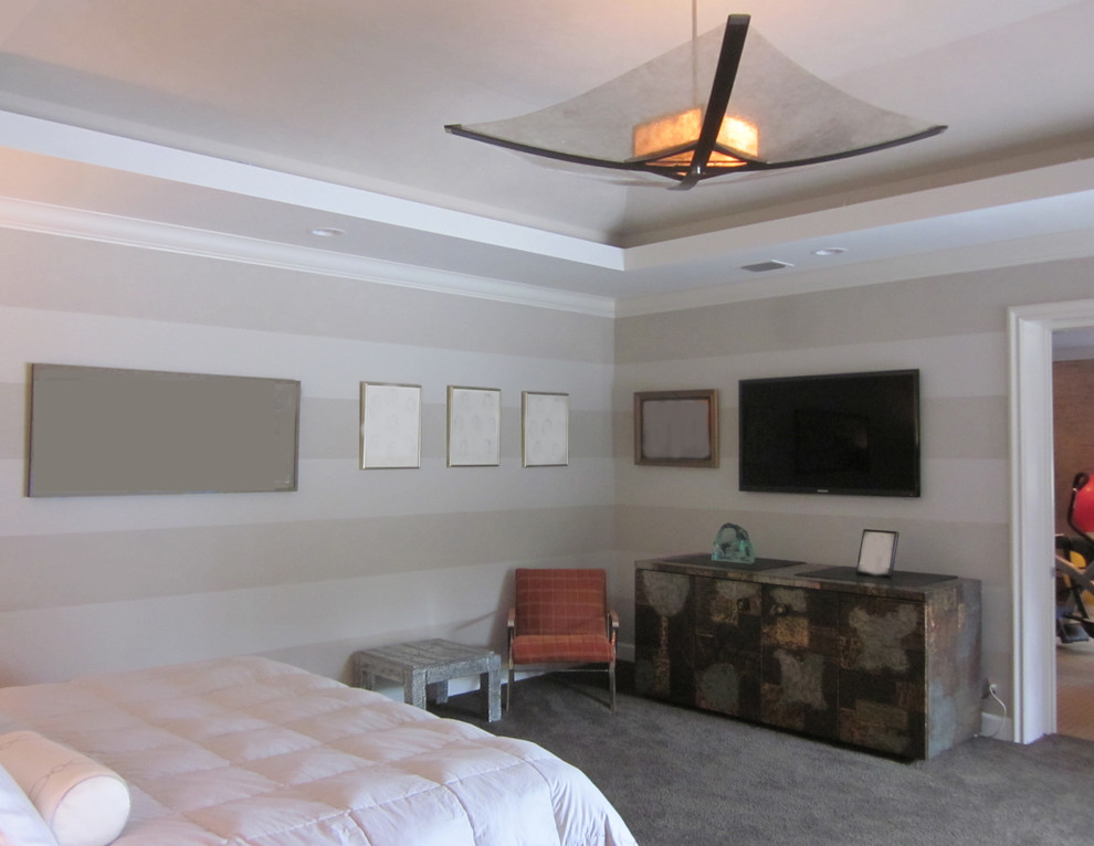 This is an example of a large modern master bedroom in New York with grey walls and carpet.