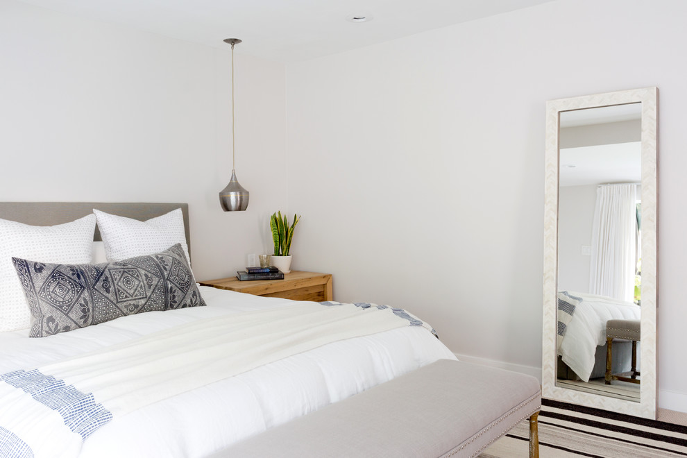 This is an example of a large contemporary master and grey and silver bedroom in Los Angeles with beige walls, carpet and beige floors.