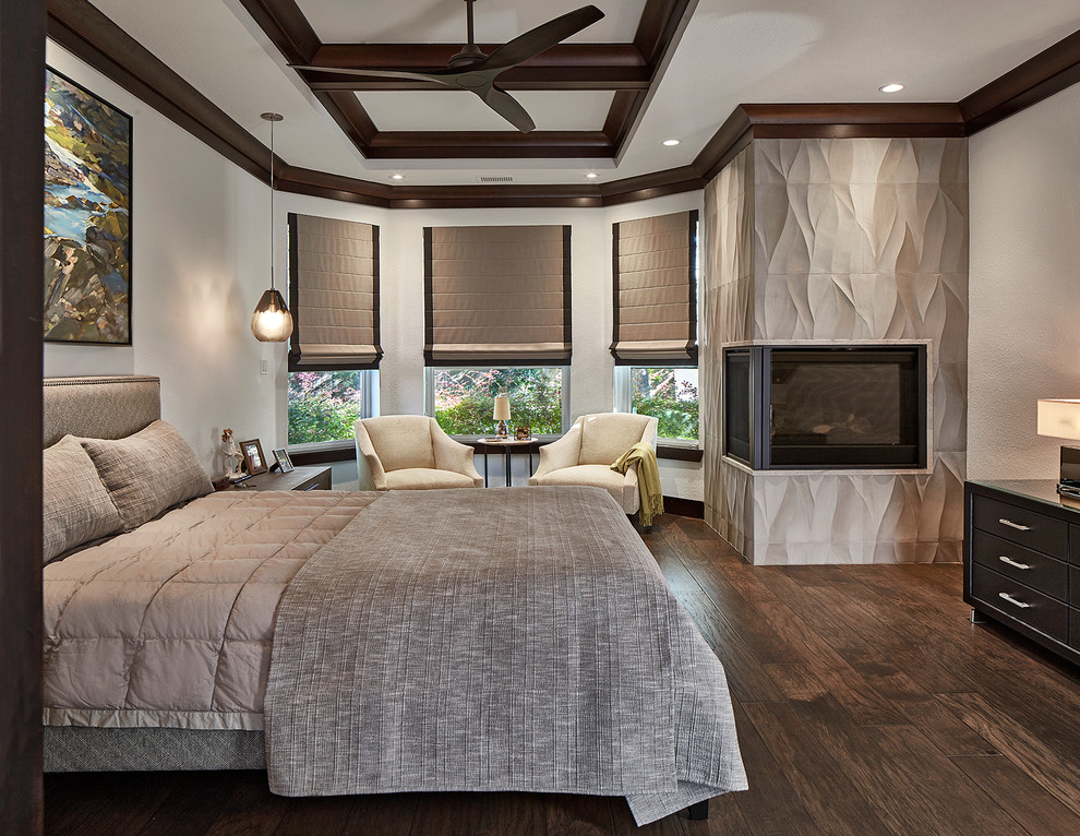 Стильный дизайн: большая хозяйская спальня в классическом стиле с серыми стенами, темным паркетным полом и угловым камином - последний тренд