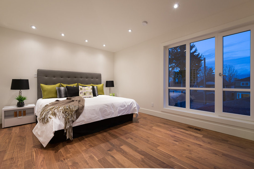 Kleines Mid-Century Hauptschlafzimmer ohne Kamin mit weißer Wandfarbe und braunem Holzboden in Vancouver