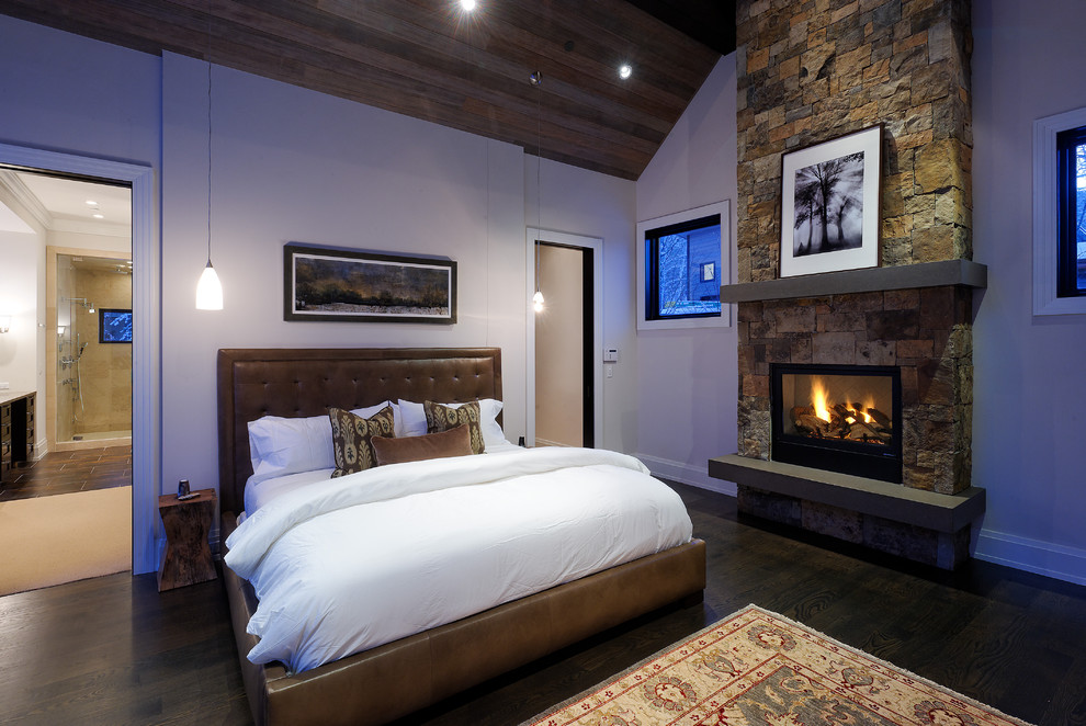 This is an example of a rustic bedroom in Denver with a stone fireplace surround and a standard fireplace.