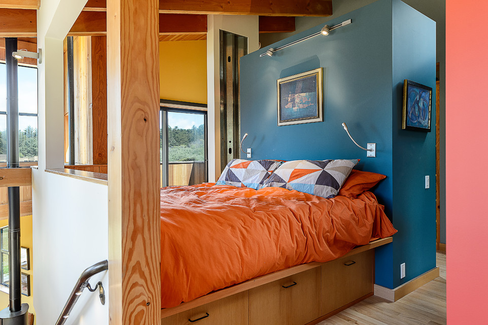 Ejemplo de dormitorio principal minimalista grande con paredes azules y suelo de madera clara