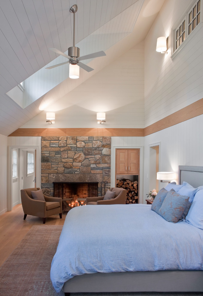 Modernes Schlafzimmer mit weißer Wandfarbe, braunem Holzboden, Kamin und Kaminumrandung aus Stein in Boston